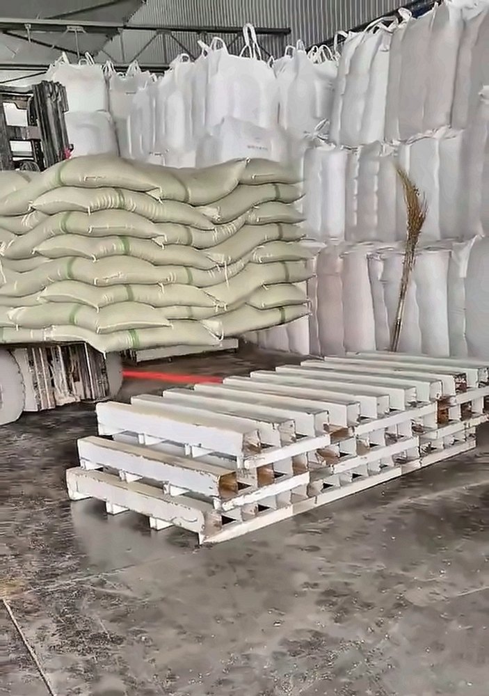 Plastic pallets and bagged stacks on the warehouse floor